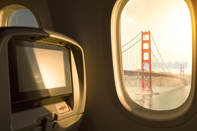 美国加利福尼亚州旧金山市日落/日出天空鸟瞰图从机场起飞后，从窗口飞机经济舱座位。